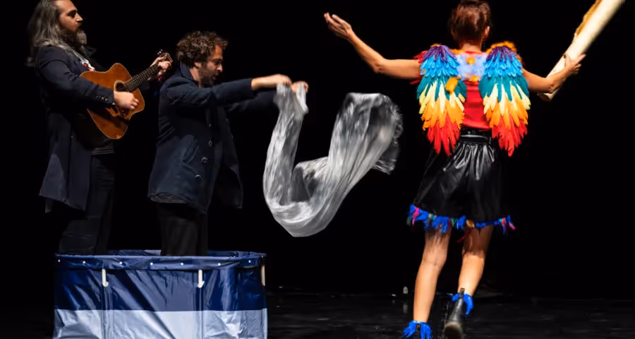 Performer con ali colorate al Festival di Spoleto, musica e movimento sul palco