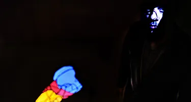 Festival di Spoleto performance with colorful abstract figures on dark stage