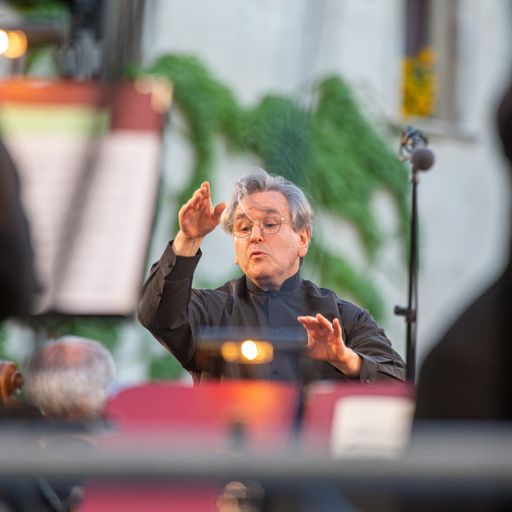 Conductor performing at Festival di Spoleto, passionately leading orchestra with expressive gestures