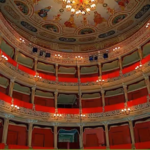 Teatro elegante al Festival di Spoleto con balconate rosse e lampadario sfarzoso