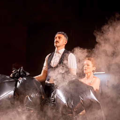 Spettacolo teatrale al Festival di Spoleto con attori tra sacchi e fumo
