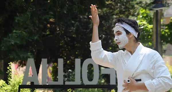 Performer con maschera bianca al Festival di Spoleto, braccio alzato