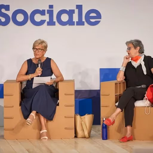 Festival di Spoleto speakers discuss social topics on stage with blue backdrop