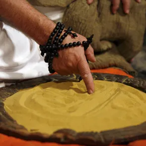 Mano con braccialetti che tocca una superficie gialla al Festival di Spoleto
