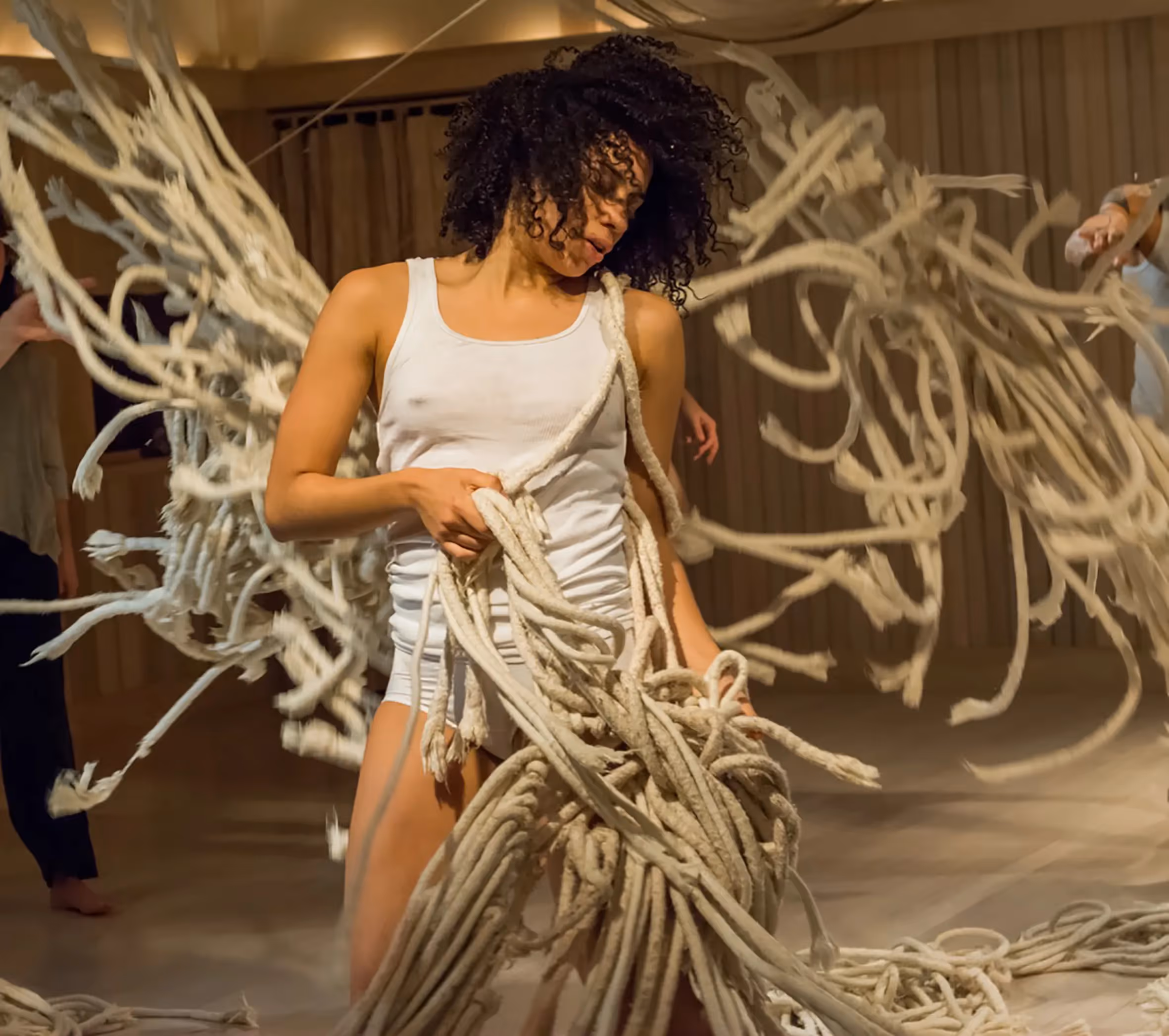 Expressive dancer in white performs with tangled ropes at Festival di Spoleto
