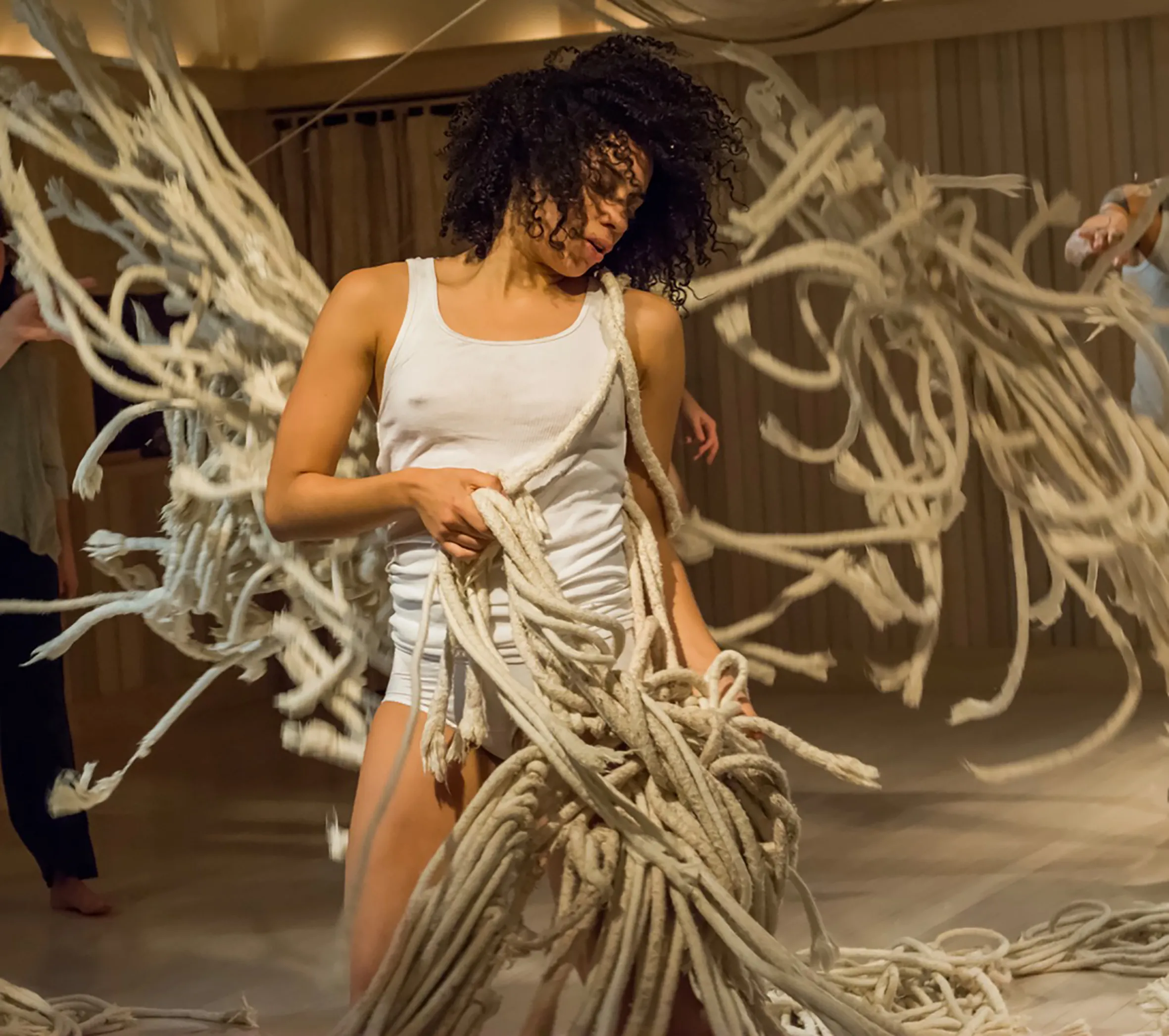 Expressive dancer in white performs with tangled ropes at Festival di Spoleto