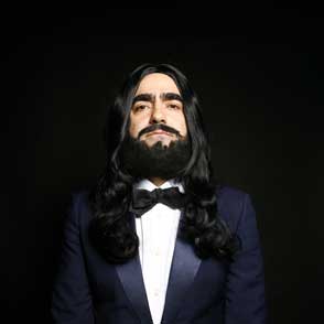 Artista elegante al Festival di Spoleto con smoking e capelli lunghi