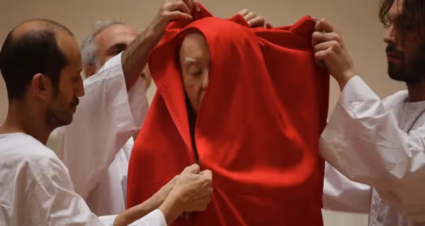 Performer avvolto in un drappo rosso al Festival di Spoleto