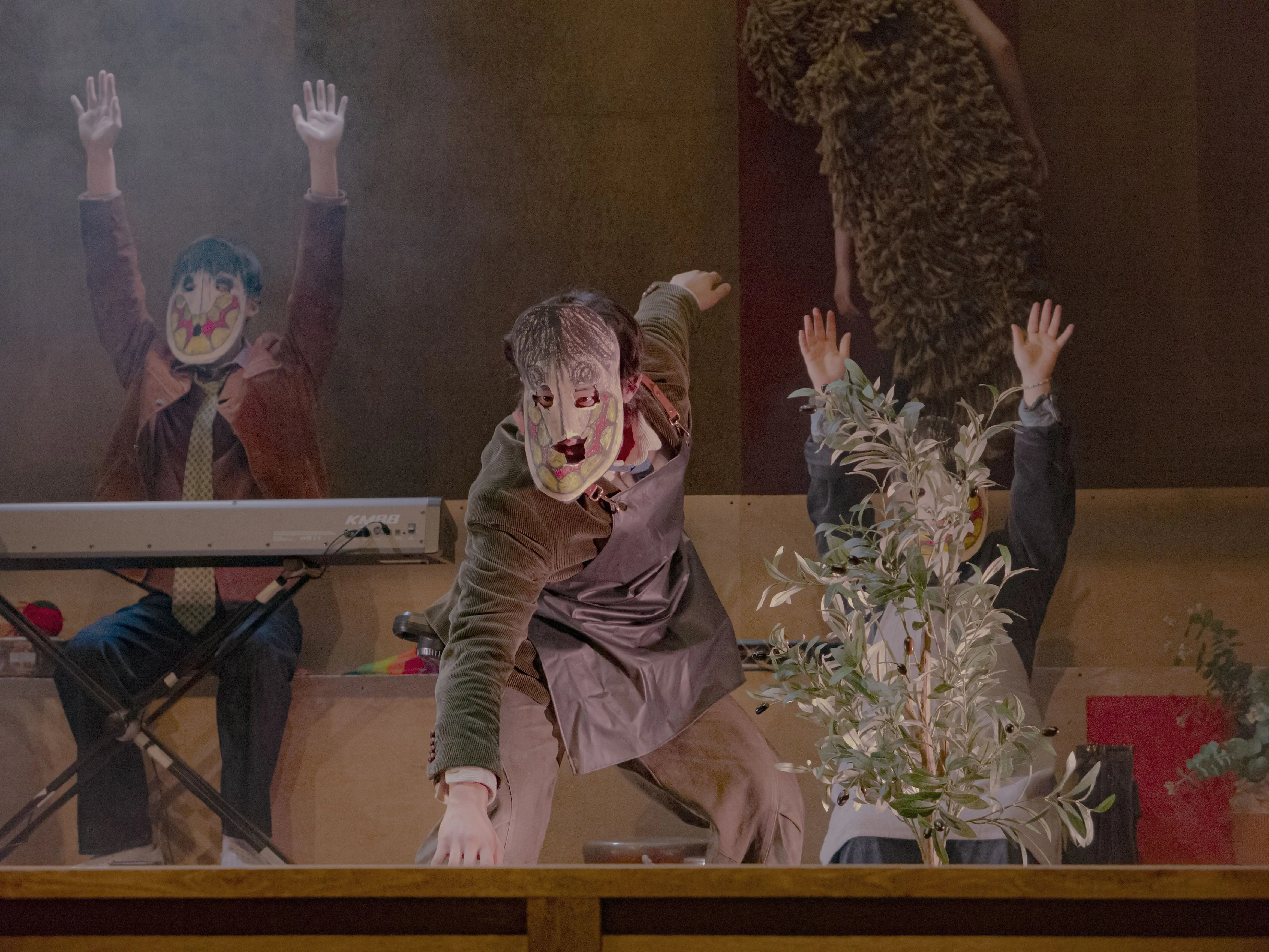 Surreal masked performers at Festival di Spoleto, theatrical stage with raised hands
