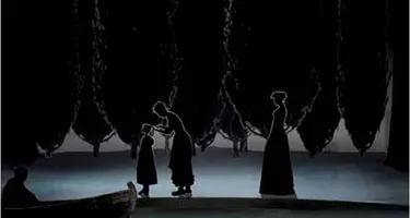 Performers silenziosi sul palco al Festival di Spoleto, ombre drammatiche intrecciate