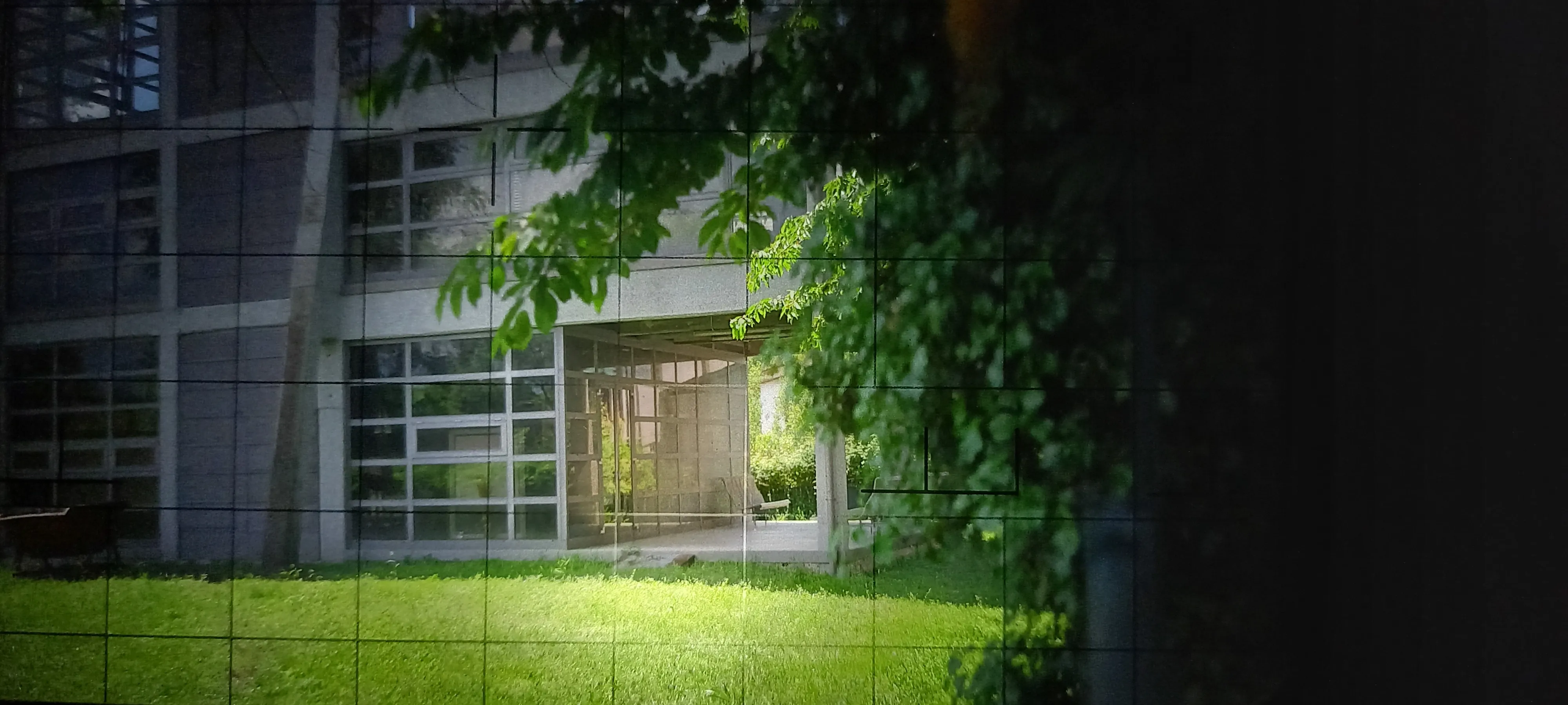 Modern glass building at Festival di Spoleto with lush green foliage