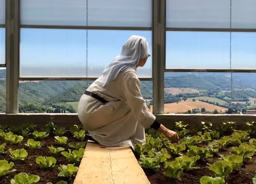Suora nel Festival di Spoleto contempla il paesaggio umbro dal suo orto