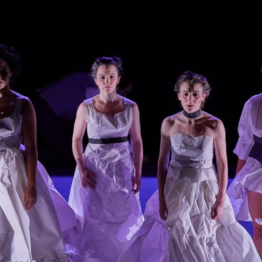 Dancers in white dresses perform at Festival di Spoleto, dramatic stage lighting