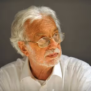 Elderly artist contemplating Festival di Spoleto, wearing glasses and white shirt