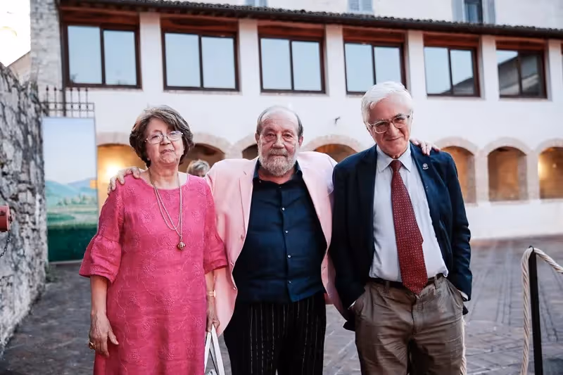 Elderly trio at Festival di Spoleto, standing together in historic Italian setting