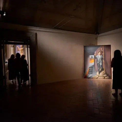 Mostra artistica al Festival di Spoleto con visitatori e opera surreale illuminata