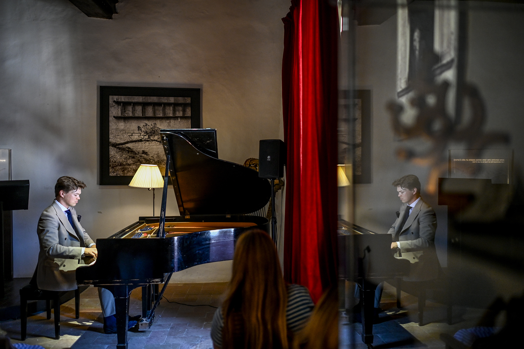 Pianist performing at Festival di Spoleto, intimate concert with red curtain backdrop