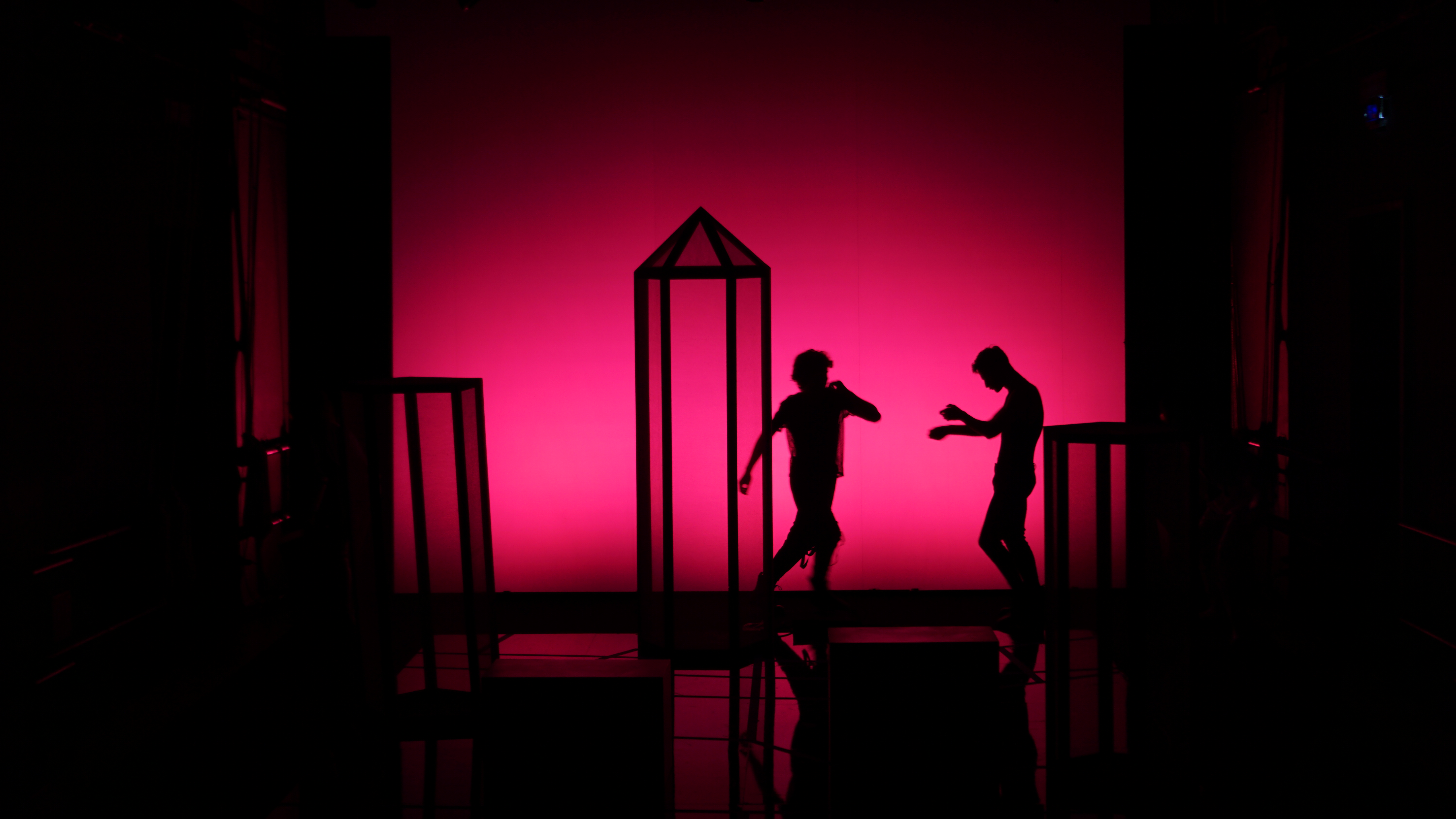 Sagome di danzatori sul palco del Festival di Spoleto con sfondo rosa intenso