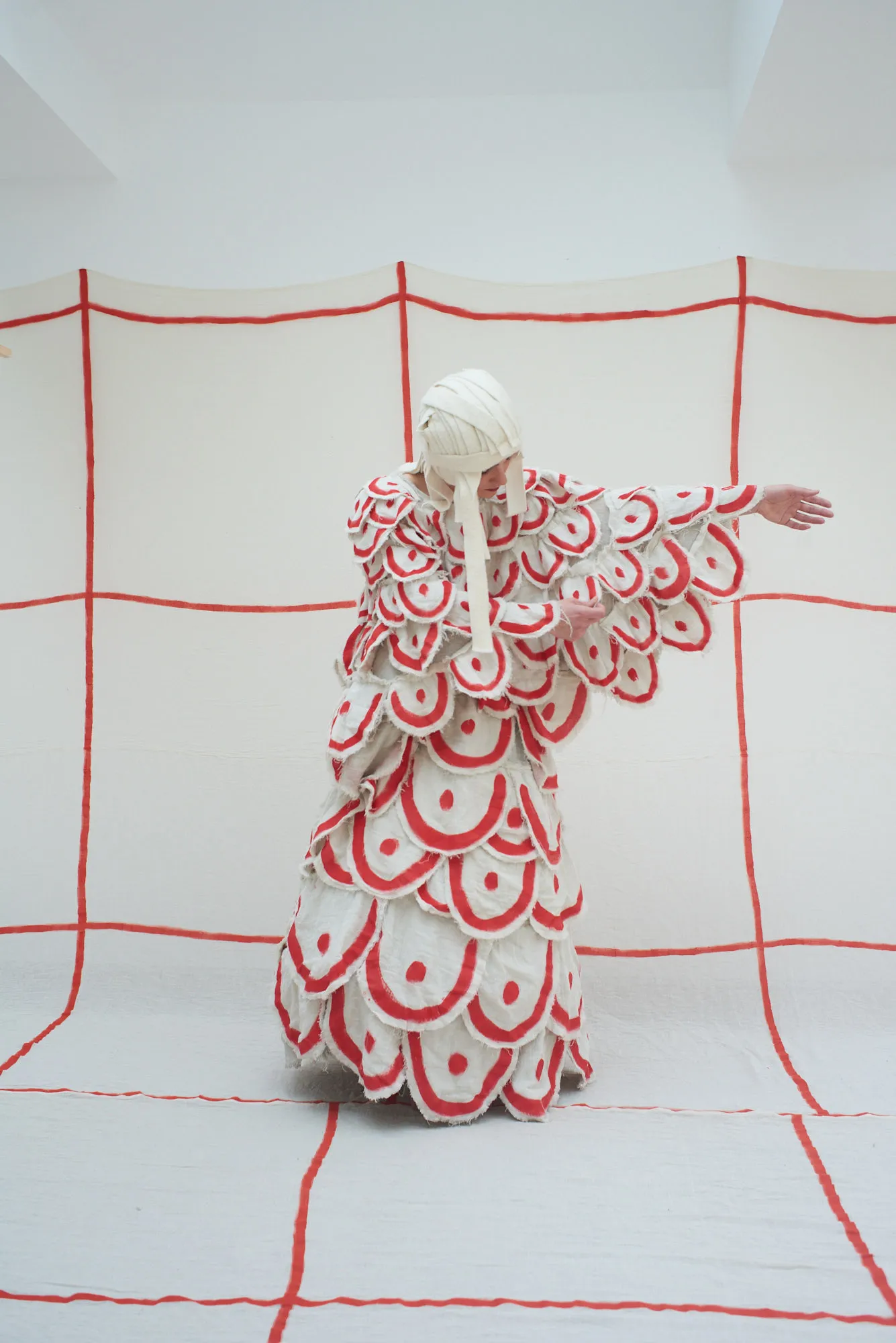 Performance artistica al Festival di Spoleto con costume a scaglie rosso-bianco