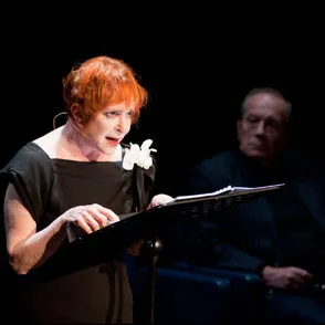 Performer reading on stage at Festival di Spoleto with dramatic lighting