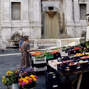 Mercato colorato al Festival di Spoleto con frutta fresca e architettura storica