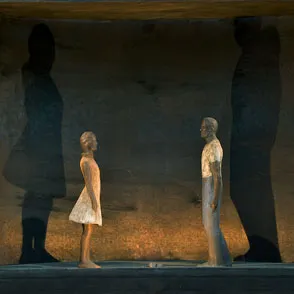 Two figures on stage at Festival di Spoleto, dramatic lighting and shadows