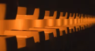 Sedute arancioni prospettiva Festival di Spoleto, file geometriche ravvicinate