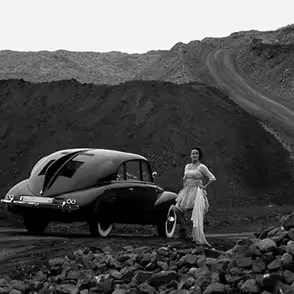 Auto d'epoca al Festival di Spoleto, donna elegante su sfondo roccioso