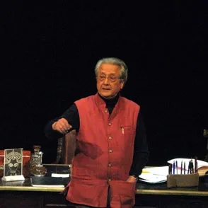 Elderly speaker in red vest at Festival di Spoleto performing onstage