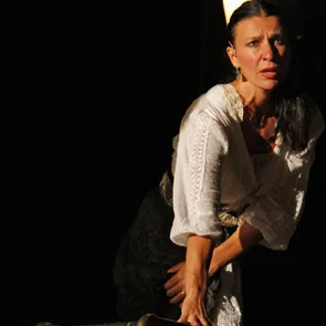 Performer drammatica al Festival di Spoleto, vestita in bianco su sfondo nero