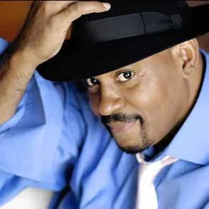 Festival di Spoleto performer in blue shirt and black hat poses dramatically