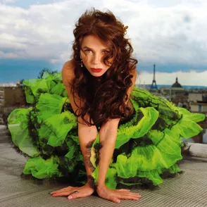 Vibrant performer in green dress at Festival di Spoleto, crouching dramatically