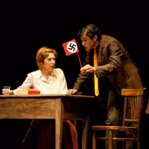 Scena teatrale intensa al Festival di Spoleto con simbolo nazista