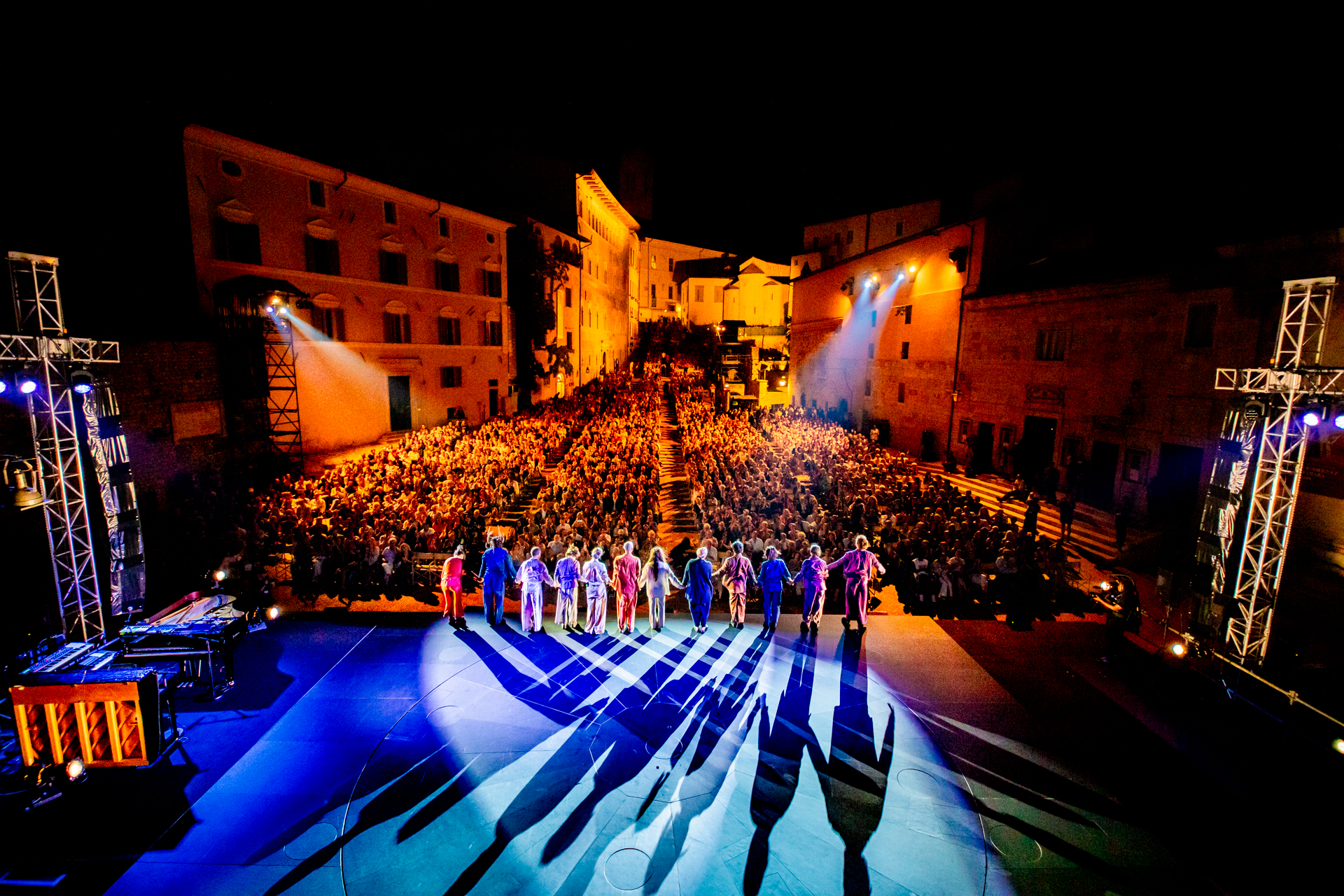 Spettacolo notturno al Festival di Spoleto con artisti e folla illuminata