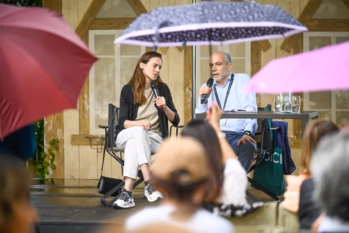 Video Festival di Spoleto: due relatori sotto ombrelli durante un incontro pubblico