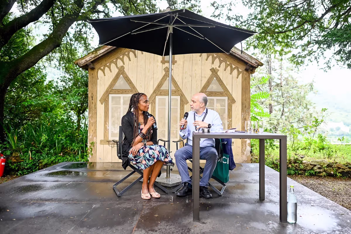 Video Festival di Spoleto speakers discussing under umbrella near wooden pavilion