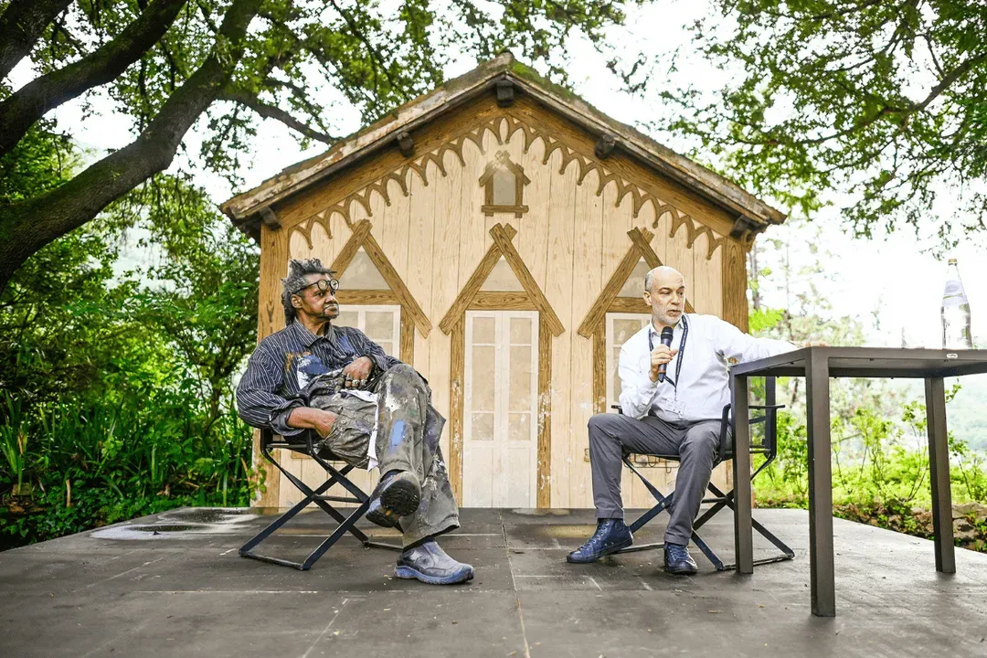 Video Festival di Spoleto: Two men seated outside wooden pavilion during event