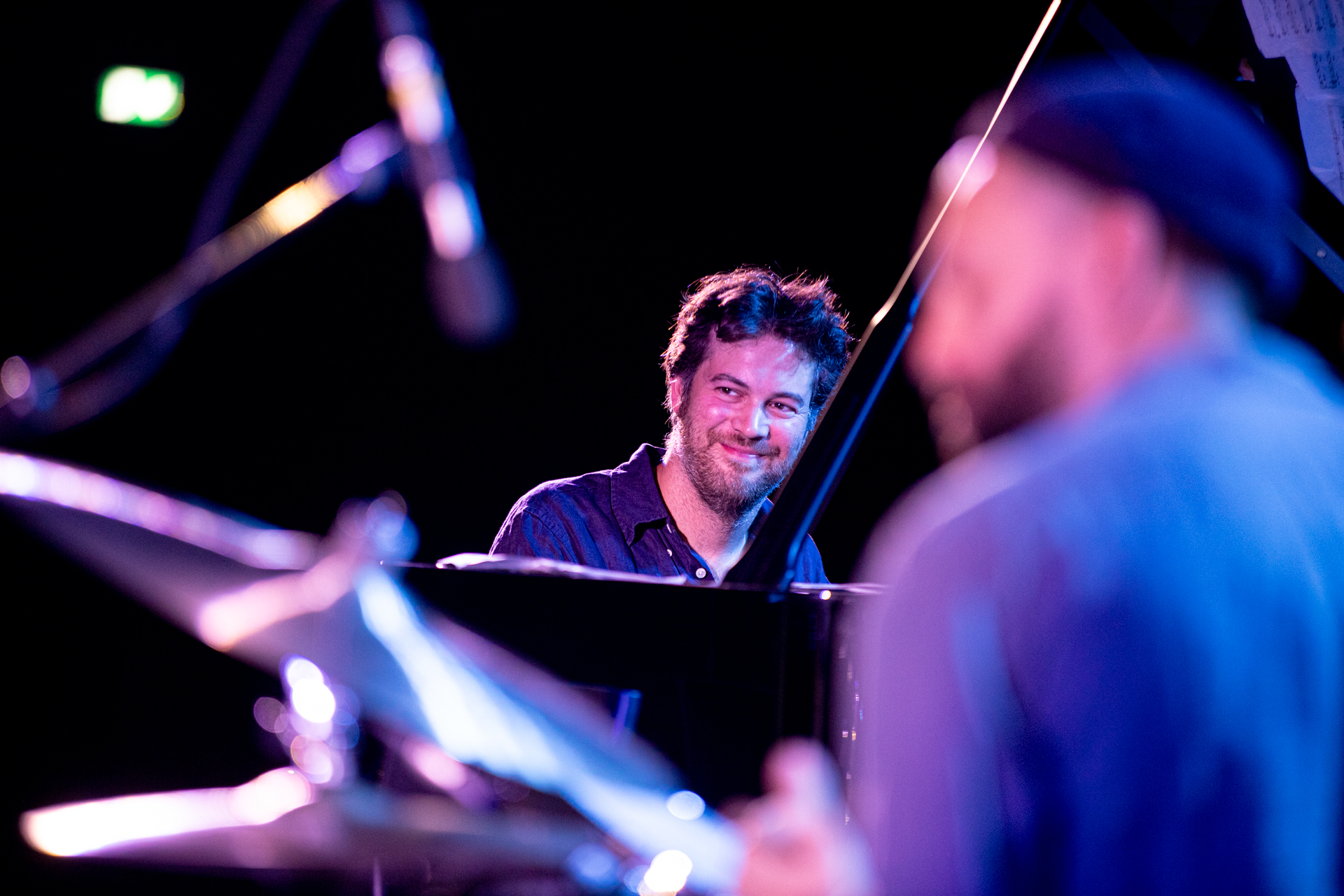 Pianista sorridente durante il Festival di Spoleto, illuminato da luci colorate