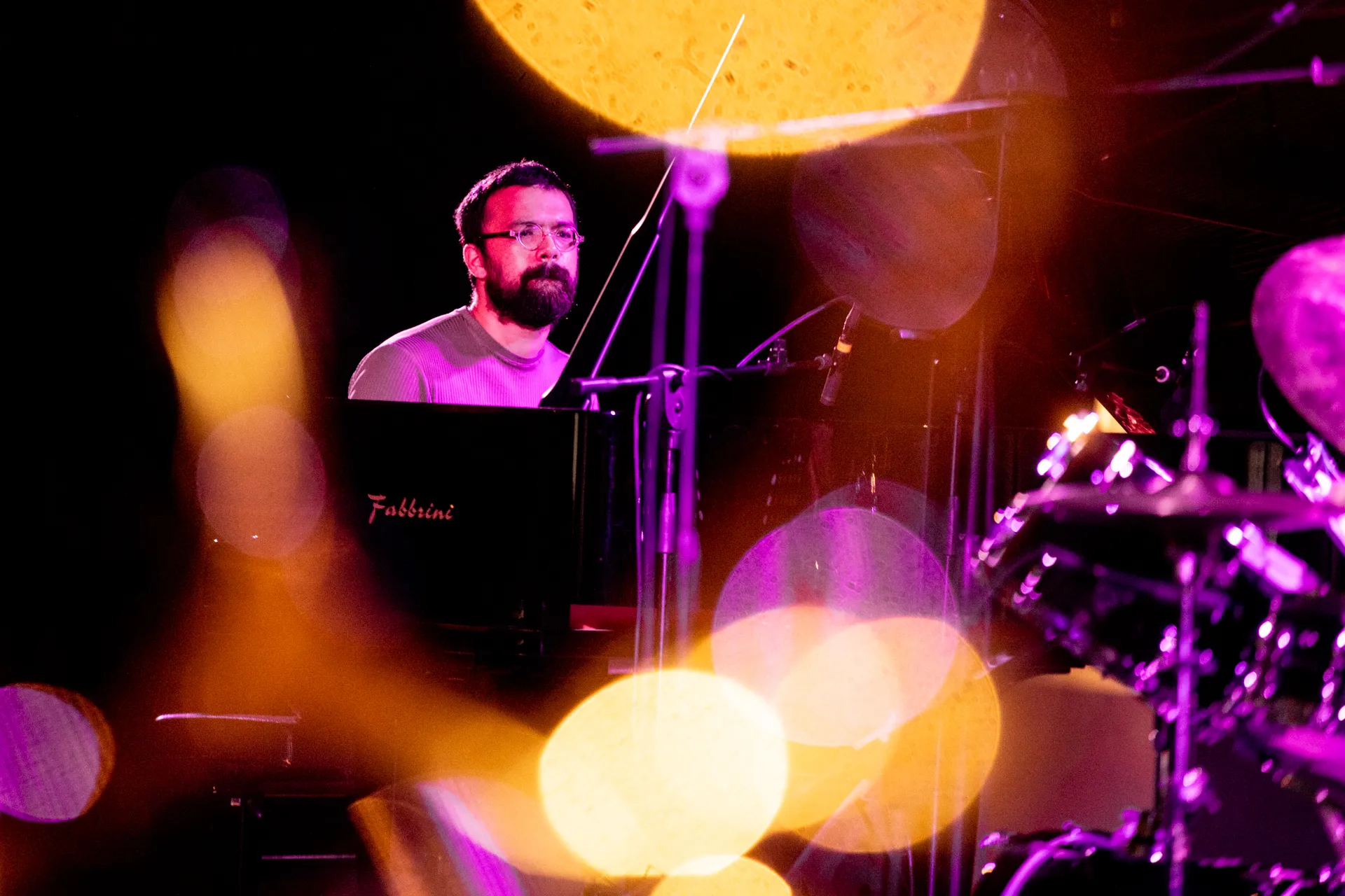 Musical performance at Festival di Spoleto with pianist surrounded by colorful lights