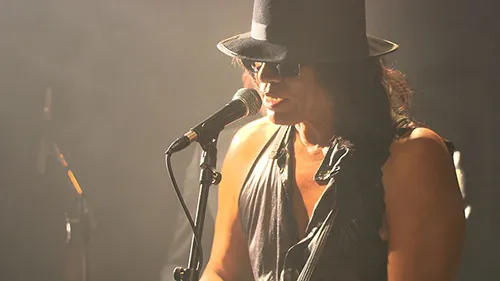 Musician performs at Festival di Spoleto, wearing hat and singing into microphone