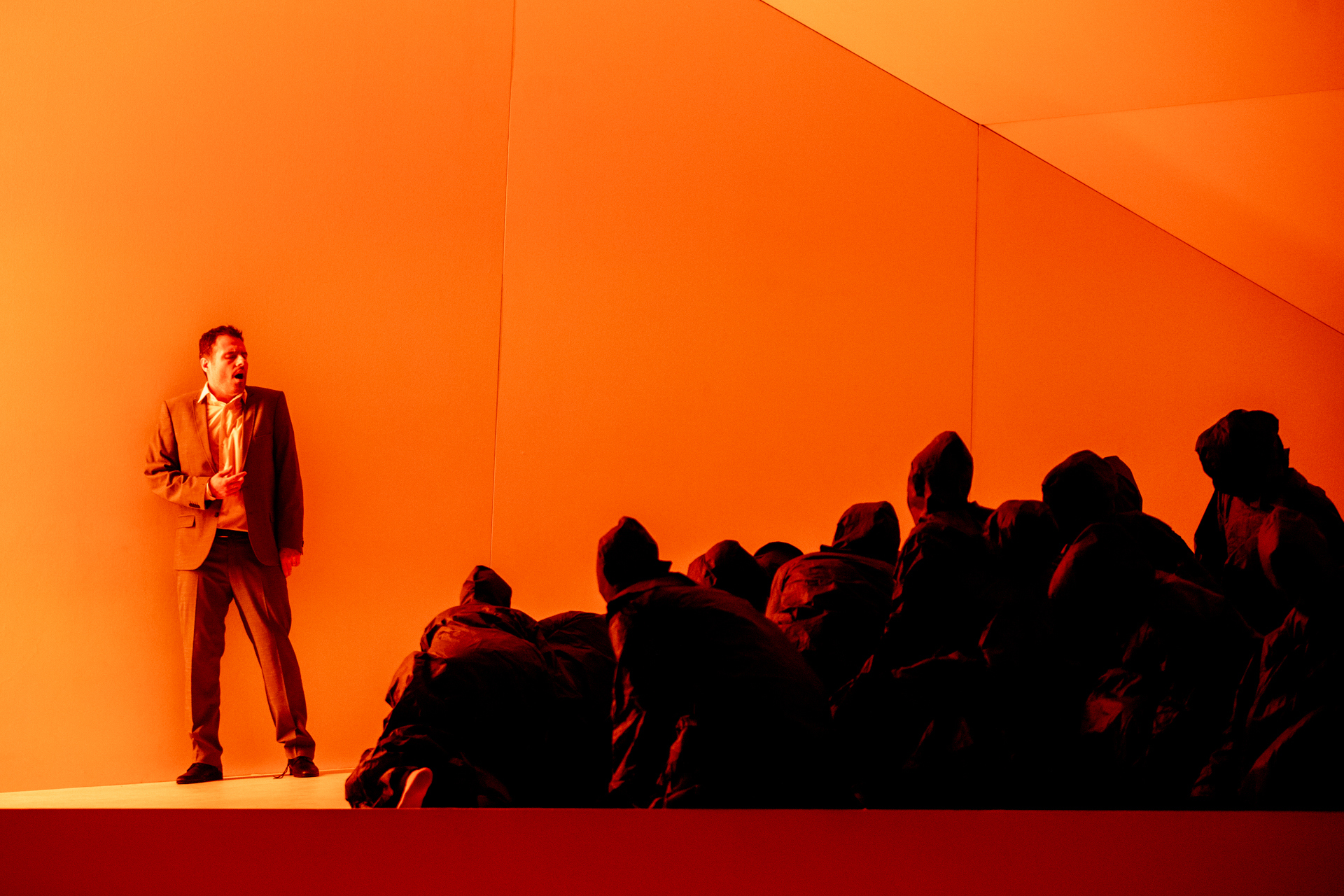 Performance teatrale al Festival di Spoleto con attore su sfondo arancione
