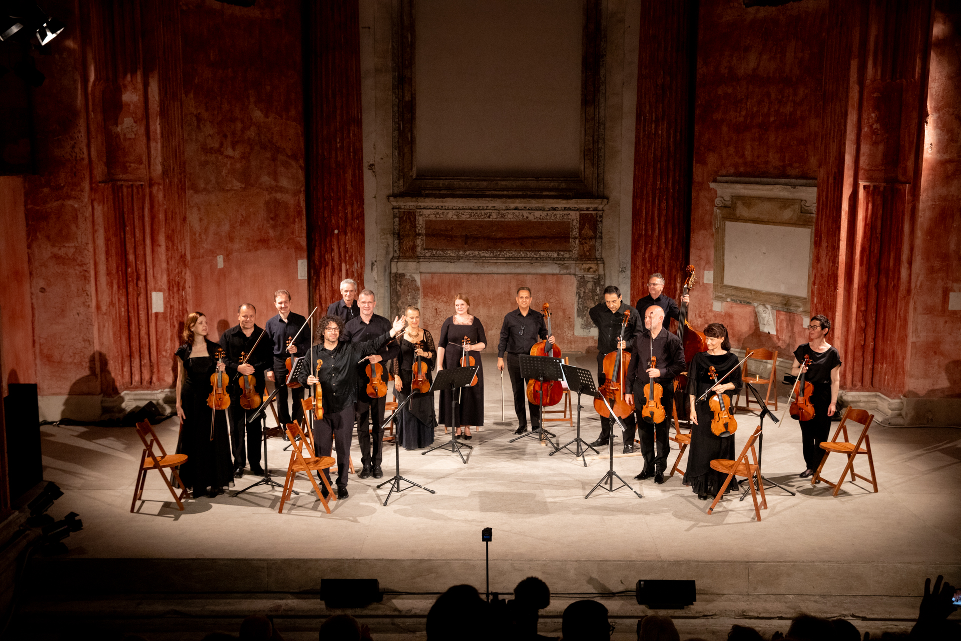 Orchestra performing at Festival di Spoleto in historic red-walled concert venue