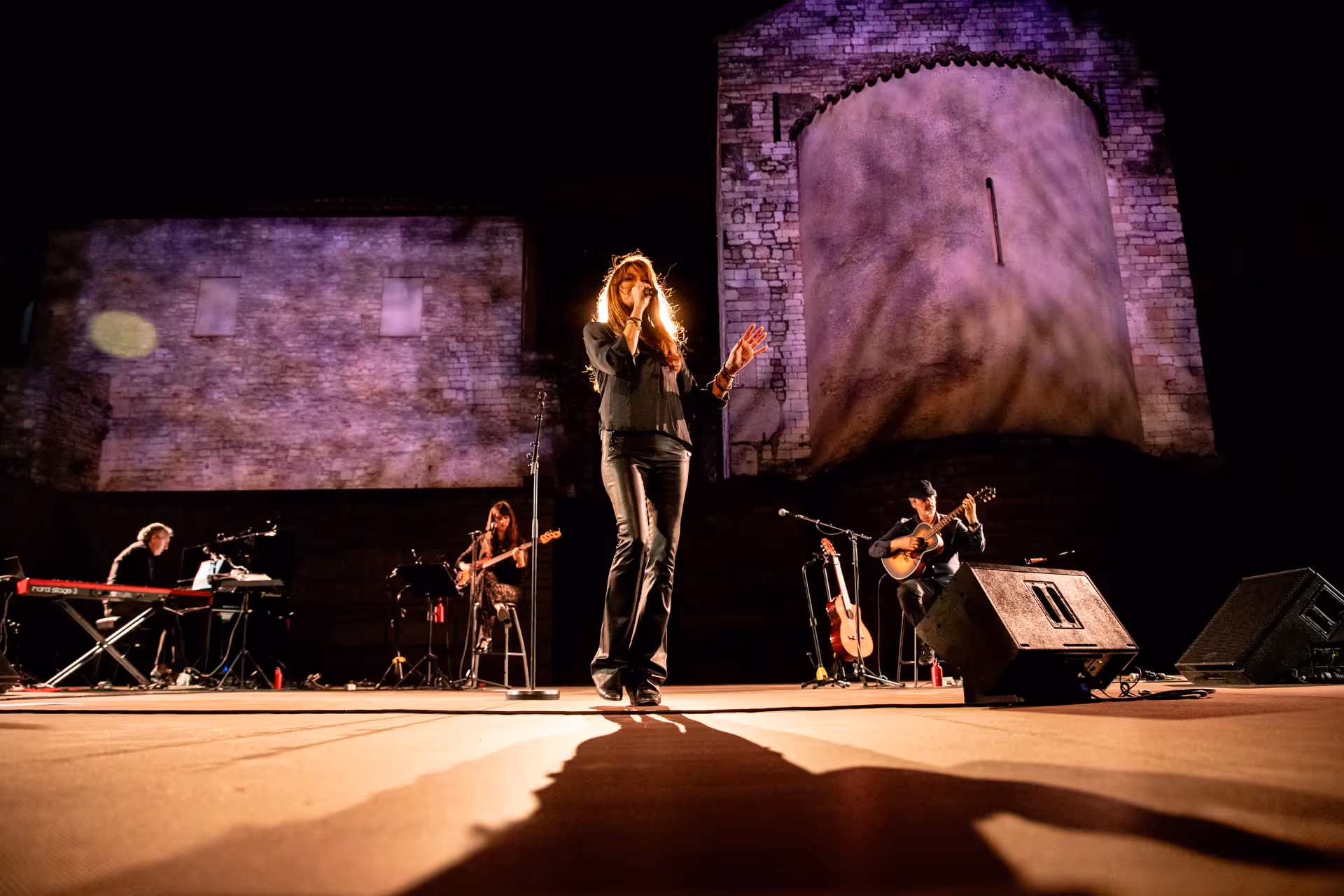 Musical performance at Festival di Spoleto with band on stone-wall stage