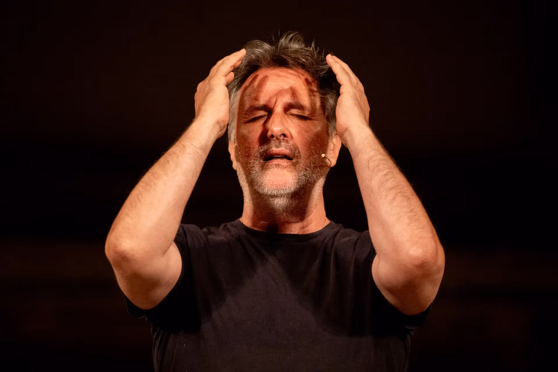 Festival di Spoleto performer expressing intense emotion on dark stage