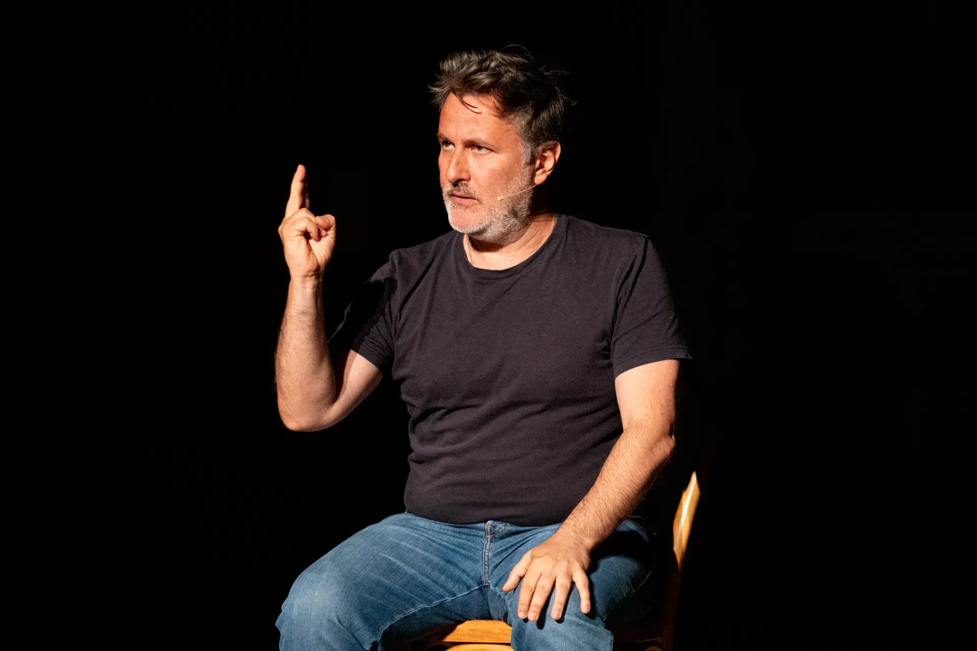 Performer durante il Festival di Spoleto, seduto su sedia con gesto espressivo