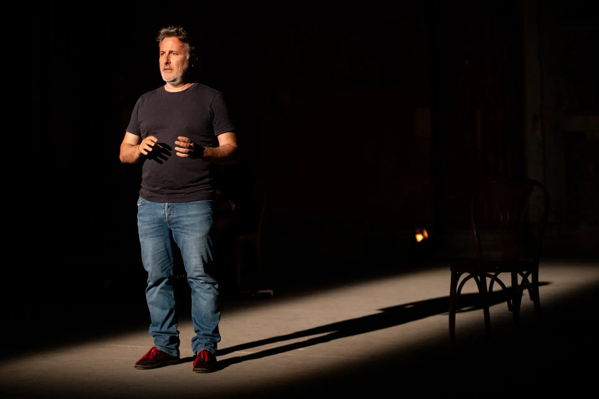 Performer sul palco durante il Festival di Spoleto, illuminato drammaticamente