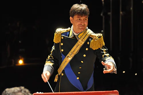 Direttore d'orchestra in uniforme al Festival di Spoleto, dirigendo con passione