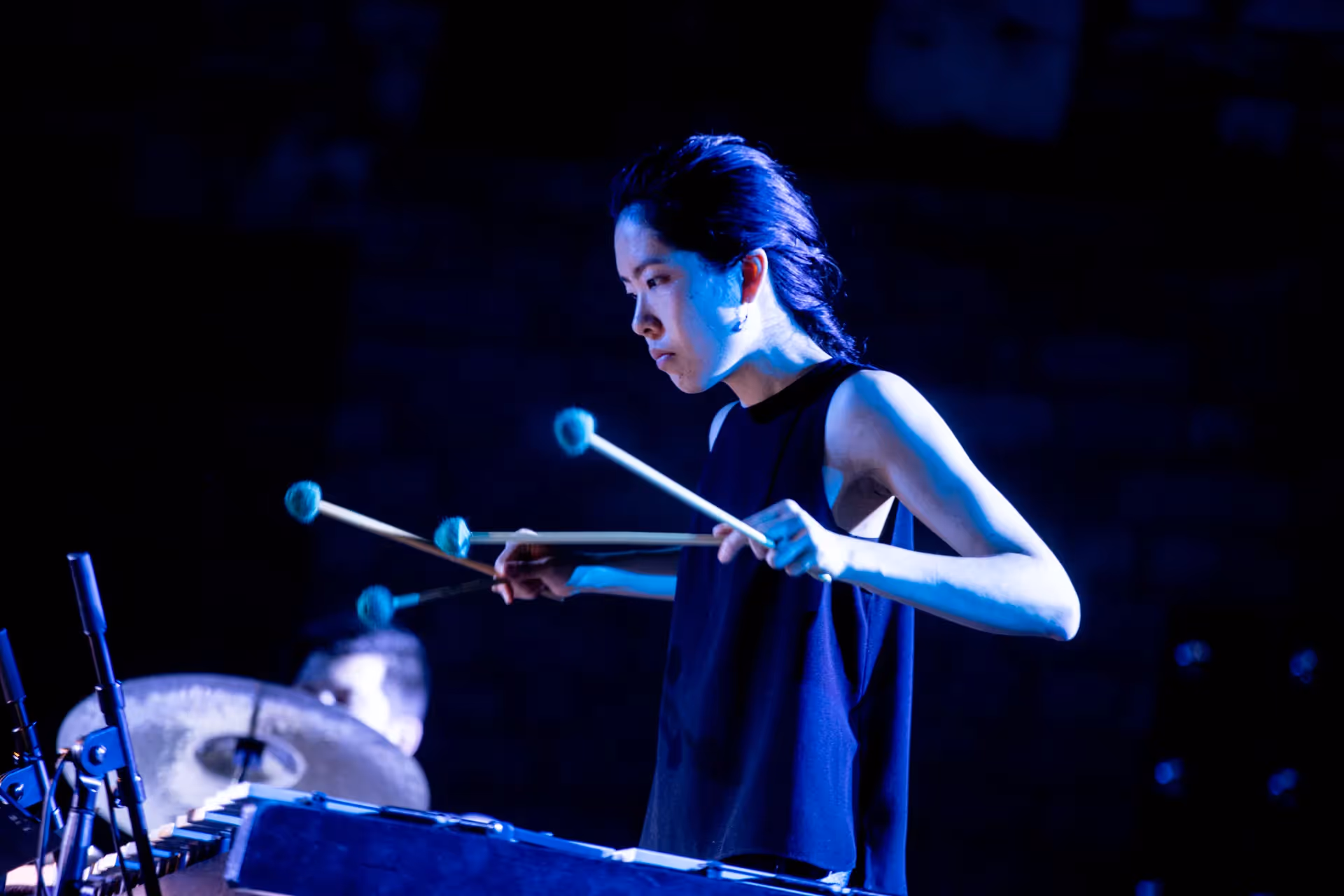 Percussionist performing at Festival di Spoleto with blue stage lighting