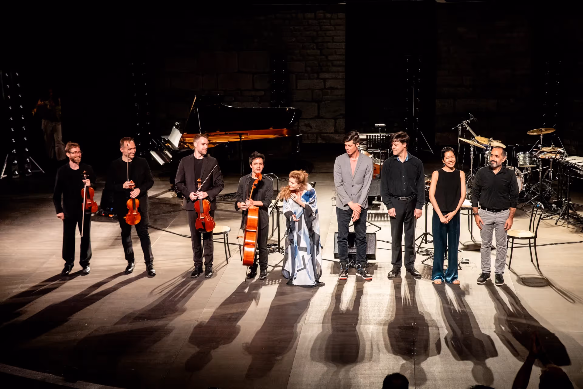 Musicians performing at Festival di Spoleto, casting dramatic shadows on stage