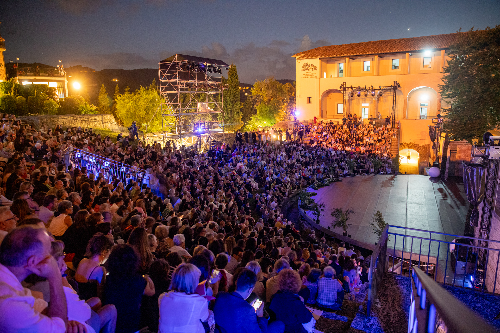 Affollata serata notturna al Festival di Spoleto con palcoscenico illuminato